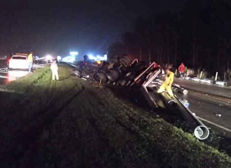 Carreta tomba, carga atinge carro e causa queda de moto