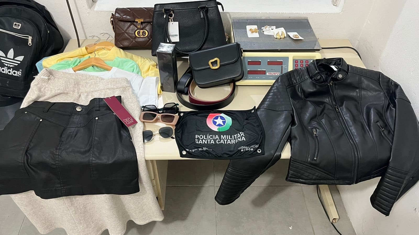 Ladrão é flagrado carregando várias peças de roupas com etiquetas e cabides