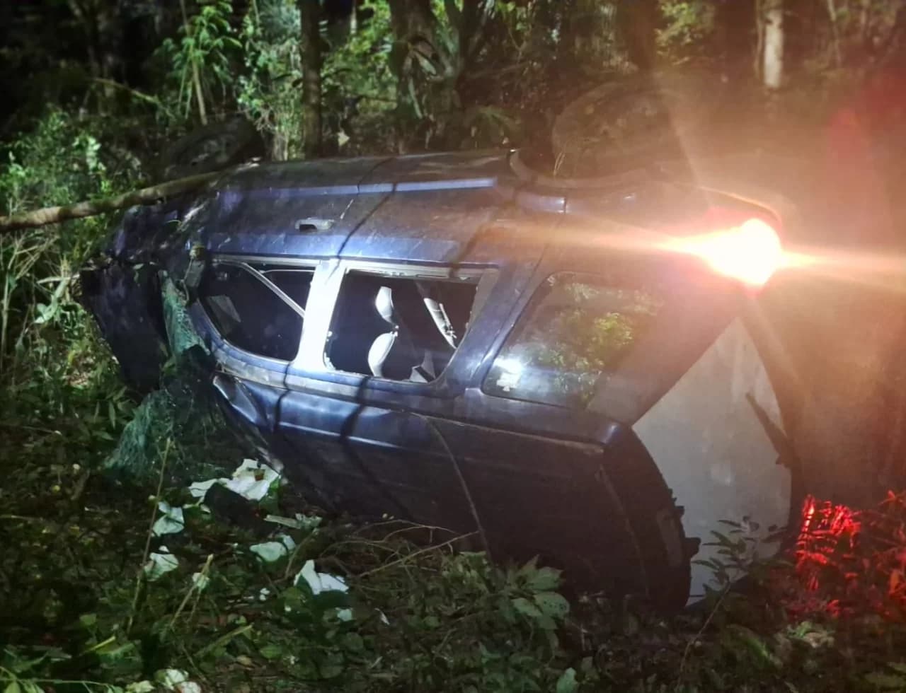 Carro capota e cai em ribanceira após colidir contra poste