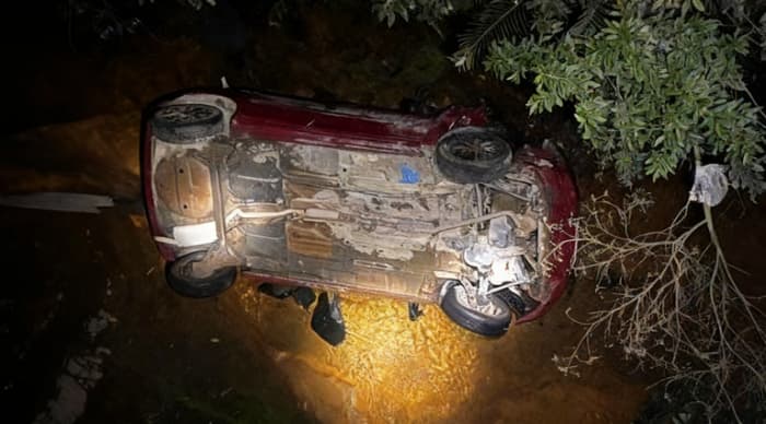 Carro despenca por cinco metros e fica parcialmente submerso em rio