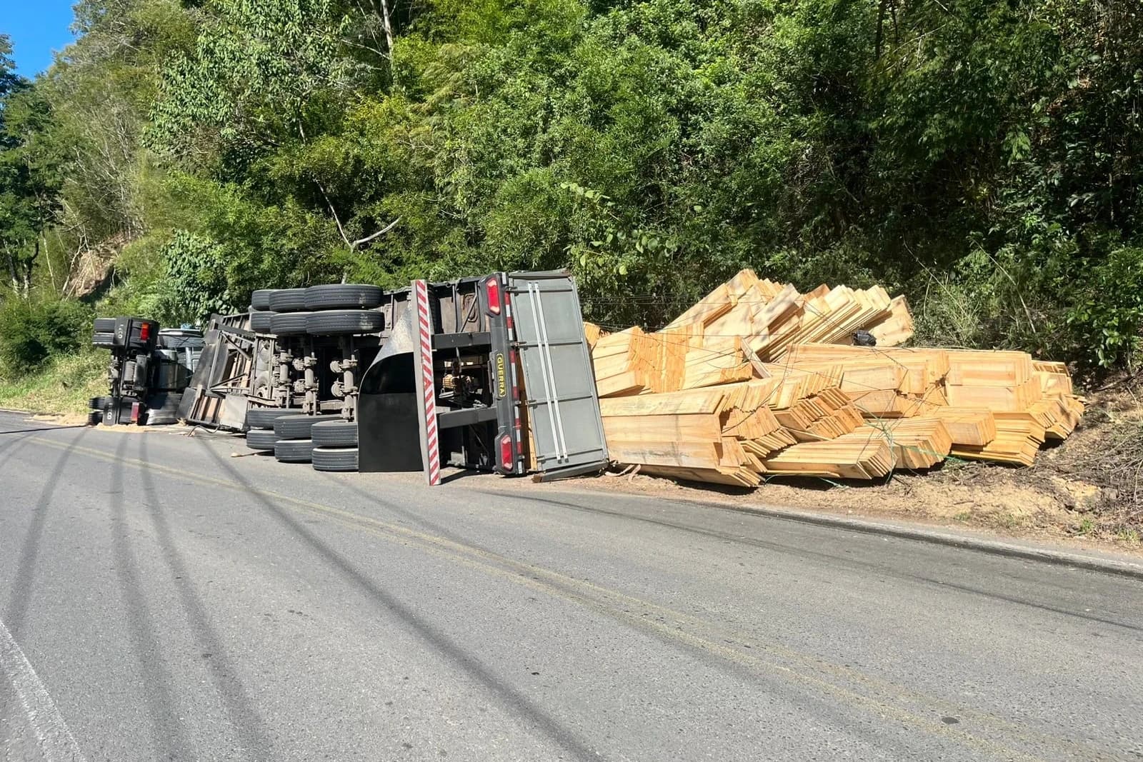 Caminhão carregado com madeira tomba na SC-435 e deixa dois feridos
