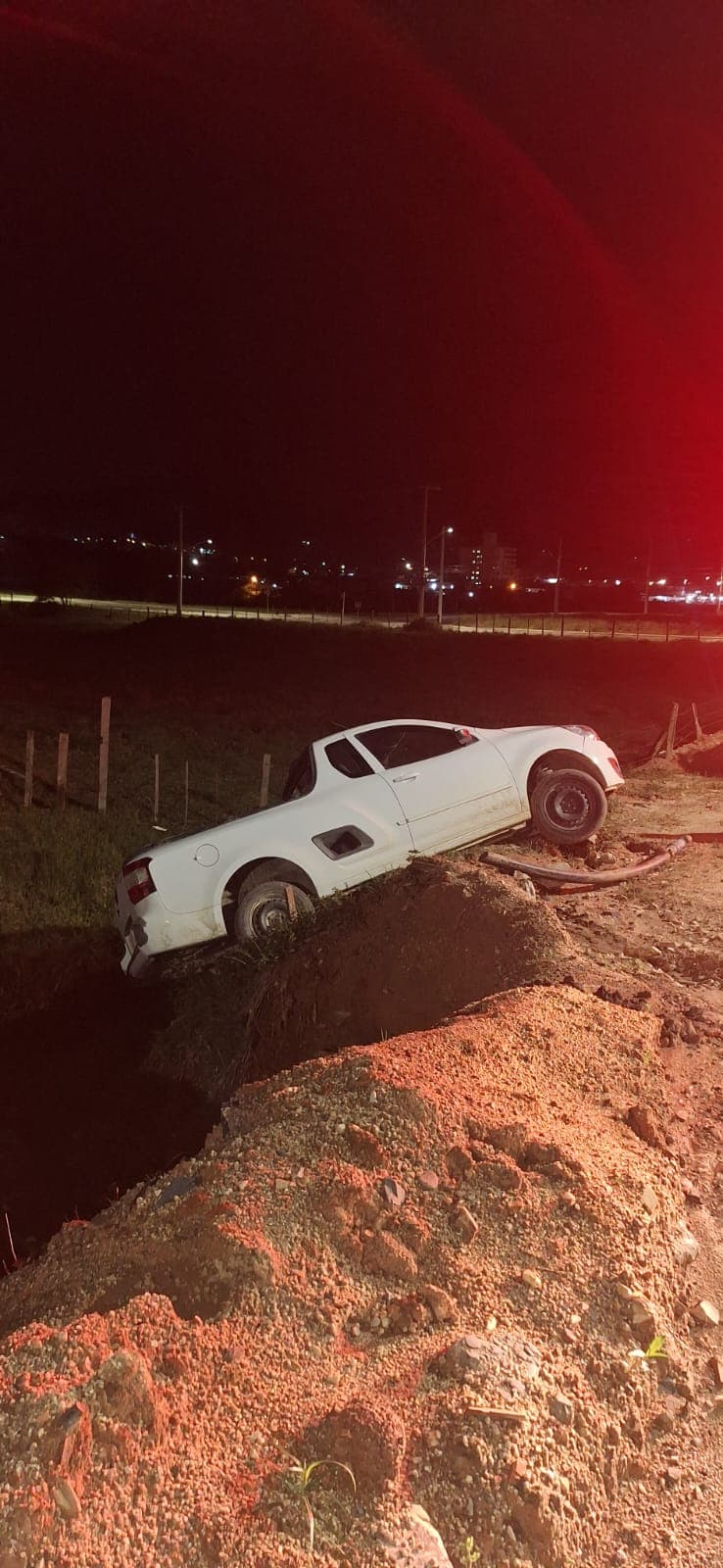 Carro sai da pista e fica pendurado sobre riacho